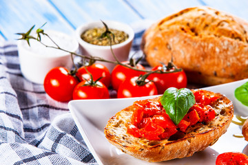 Bruschettas on white plate on wooden background