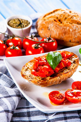 Bruschettas on white plate on wooden background