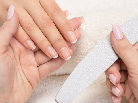 Woman gets manicure procedure in a spa salon. Beautiful female hands.