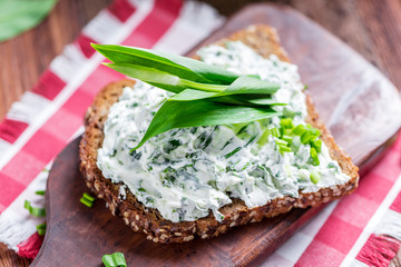 Spread of freshly harvested leaves of wild garlic (Allium ursinum) on a rustic wooden board