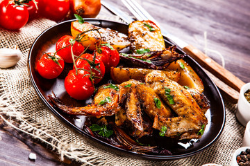 Roast chicken wings, baked potatoes and vegetables