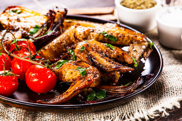 Roast chicken wings, baked potatoes and vegetables