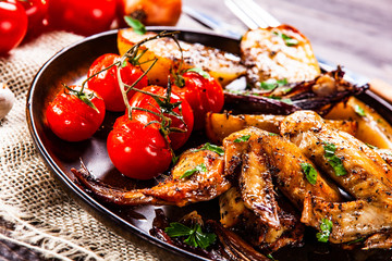 Roast chicken wings, baked potatoes and vegetables