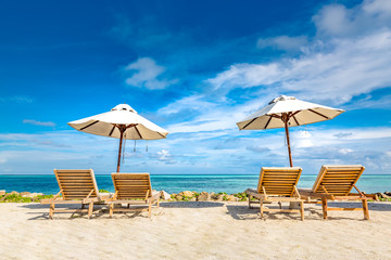Luxury couple getaway and honeymoon concept. Sun loungers and umbrella. Perfect background for...