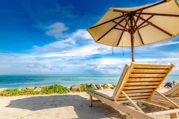 Luxury couple getaway and honeymoon concept. Sun loungers and umbrella. Perfect background for beach holiday and vacation