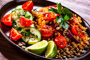 Groats with lentils and vegetables on wooden table