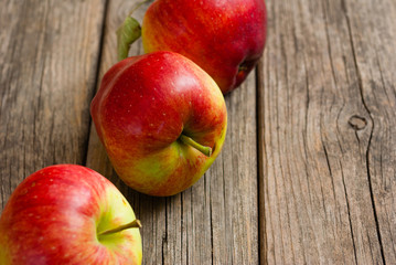 three apples on old wooden background