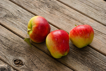 three apples on old wooden background