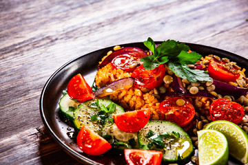 Groats with lentils and vegetables on wooden table
