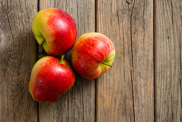 three apples on old wooden background