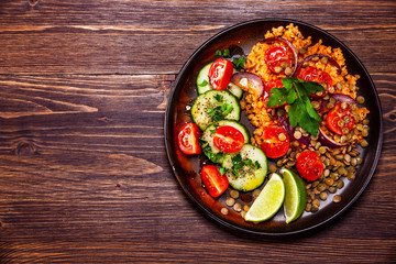 Groats with lentils and vegetables on wooden table