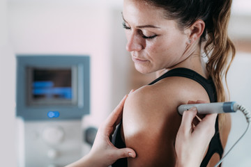 Laser therapy. Physical therapist treating patient's shoulder