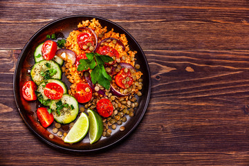 Groats with lentils and vegetables on wooden table