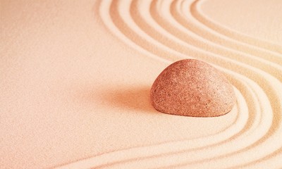 Fototapeta na wymiar Zen stone in the sand on Background