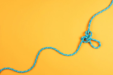 Rope and knot on yellow background.