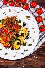 Groats with lentils and vegetables on wooden table