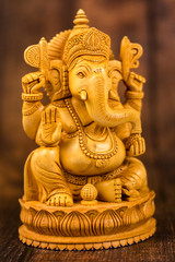Ganesha statue on a wooden background