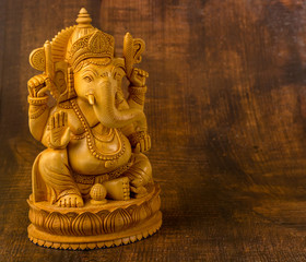 Ganesha statue on a wooden background