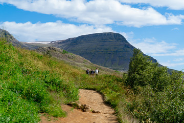 Fototapeta premium Hikers walking towards tall mountain
