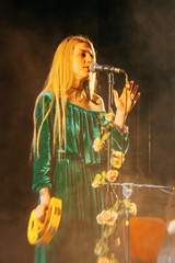Young blond woman singer in concert light