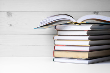 A stack of books on a wooden background.