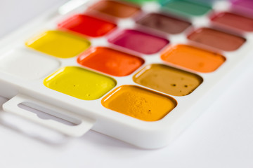 Multi-colored bright Watercolor paints on a table close up