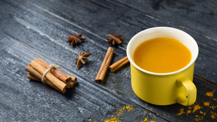 Obraz na płótnie Canvas tea with turmeric on a dark wooden background