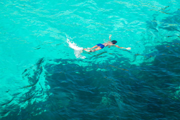 Obraz na płótnie Canvas Boy swimming in blue turquoise water