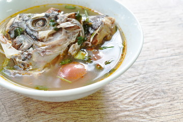 spicy boiled Tilapia head fish in tom yum soup on bowl