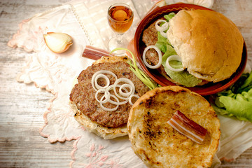 Homemade hamburger (burger) and plum brandy on table