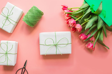 Spring. Mother day. Gifts and red tulip flowers in green paper bag on pink. Top view with copy space. - Powered by Adobe