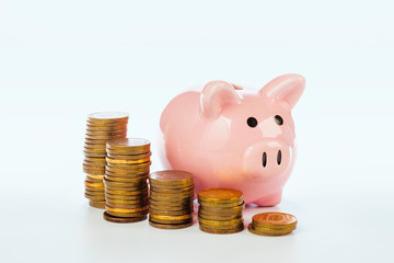 Pink piggy bank and coins isolated on white