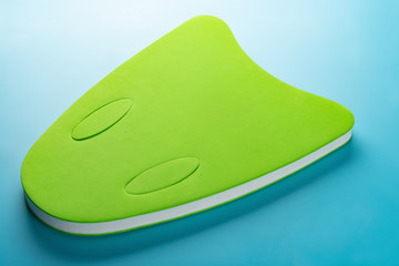 green floating pad for kids to study swimming on blue background