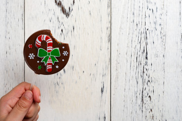 kid eating a cute Christmas lollypop on white wood background with copy space