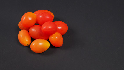 group of red tomatoes  isolated on black background,