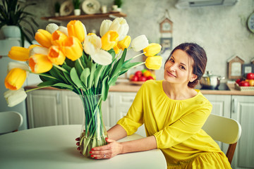 Charming, pretty girl is holding a big tulip bouquet in hands
