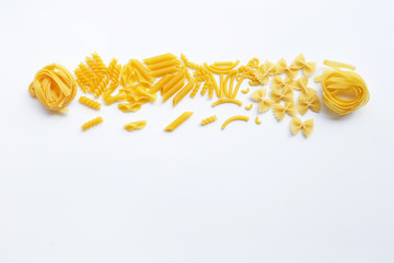 Different types of dry pasta on white.