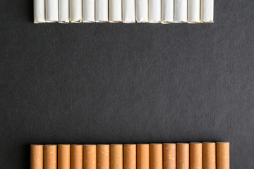 Place for text among cigarettes and tobacco, black background. Free space for inscriptions between...