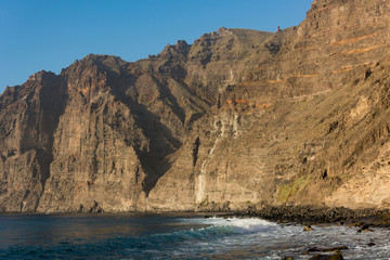 Sheer steep cliffs rising above the sea.