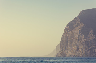 Sheer steep cliffs rising above the sea.