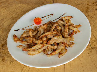 Crispy fried pork slices. Garnished with cherry tomatoes and balsamic sauce.