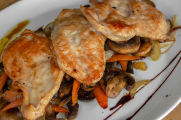 Chicken with vegetables. With chicken steaks, mushrooms, carrots and onions. With wine and pomegranate sauce.