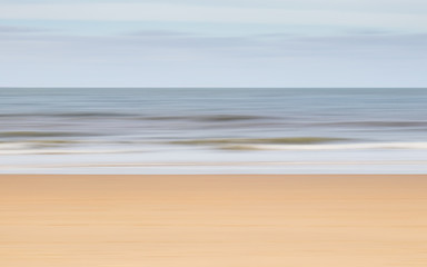 intentional camera movement to create a blurry landscape of the ocean and beach