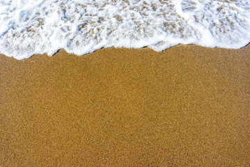 Soft wave of blue sea on sandy beach.