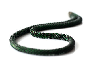 Dark green beaded necklace isolated on white background close up