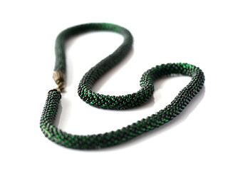 Dark green beaded necklace isolated on white background close up