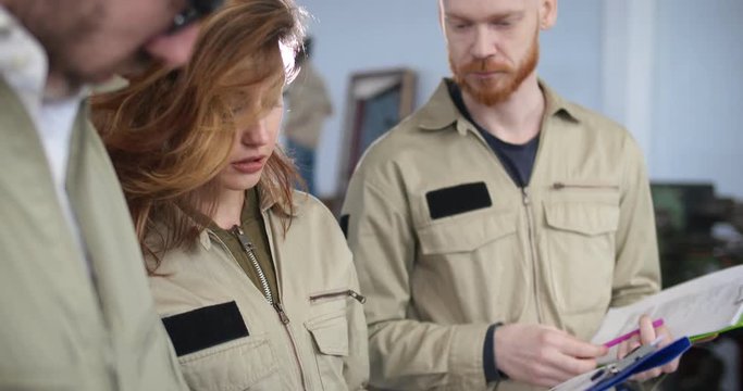 Close up of three maintenance workers discussing workplan