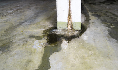 water damage in concrete construction with calcium and rust deposits and puddles