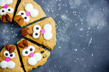 Easter bunny cookies scones decorated with cream and almonds like a funny bunnies face , Easter treats for kids