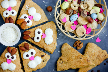 Easter bunny cookies scones decorated with cream and almonds like a funny bunnies face , Easter treats for kids